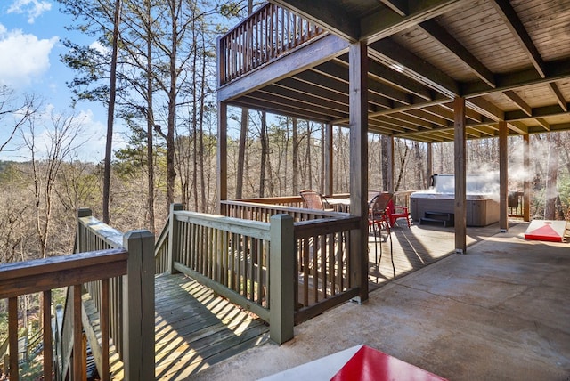 wooden deck featuring a hot tub and a patio