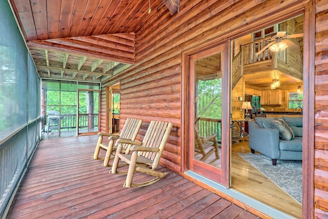 unfurnished sunroom featuring ceiling fan, lofted ceiling, and wood ceiling