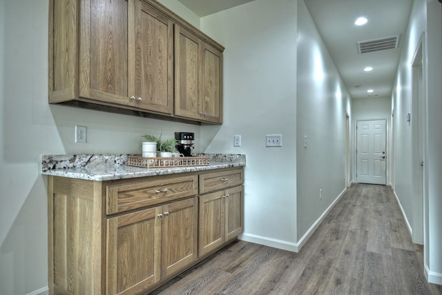 interior space featuring hardwood / wood-style floors and light stone countertops