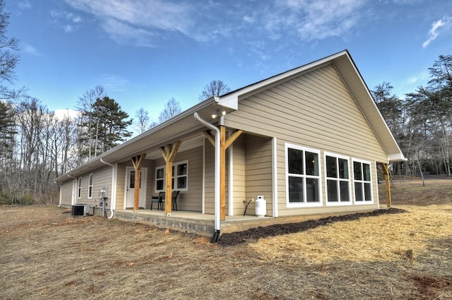 view of side of home featuring cooling unit and a patio