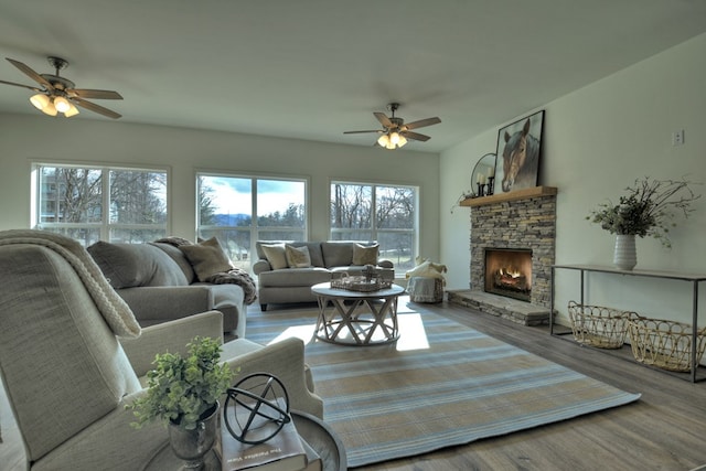 living room featuring ceiling fan, wood-type flooring, and a fireplace