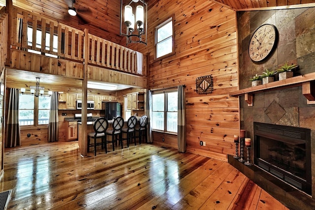 kitchen with a chandelier, hardwood / wood-style floors, plenty of natural light, freestanding refrigerator, and a high ceiling