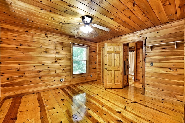 unfurnished room featuring wooden ceiling, wooden walls, ceiling fan, and hardwood / wood-style flooring