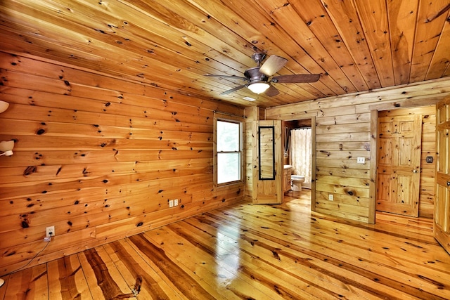 unfurnished room featuring wood ceiling, wood walls, light wood finished floors, and ceiling fan