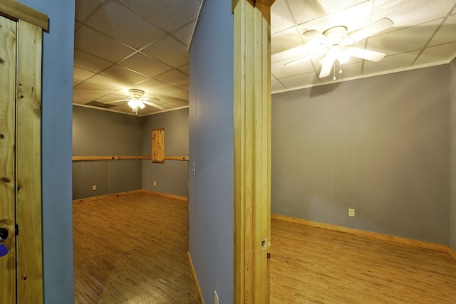 spare room with ceiling fan, wood finished floors, baseboards, and crown molding