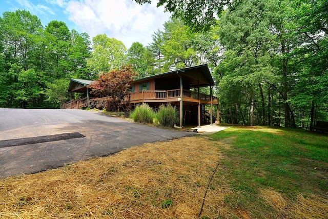 view of front of property with a wooden deck and a front yard