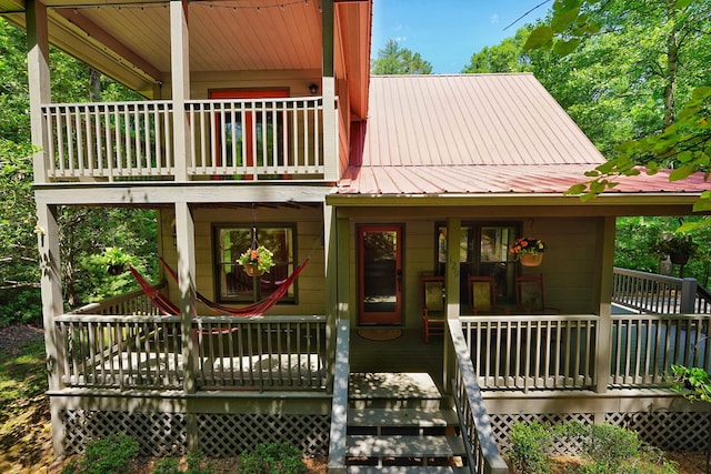 view of front of property featuring metal roof and a balcony