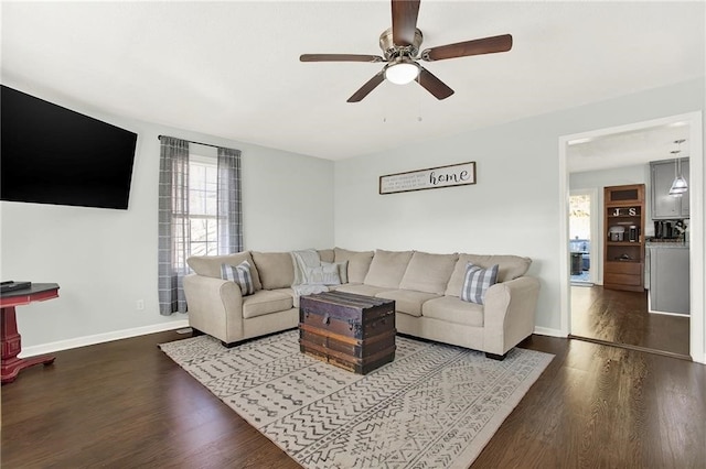 living room featuring ceiling fan and dark hardwood / wood-style floors