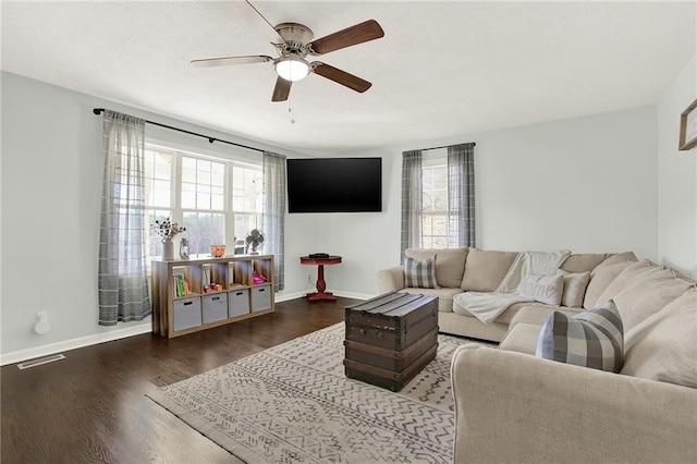 living room with dark hardwood / wood-style flooring and ceiling fan