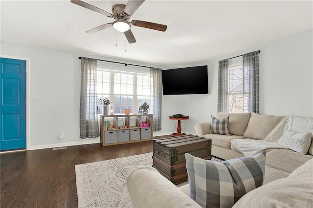 living room featuring ceiling fan and dark hardwood / wood-style floors