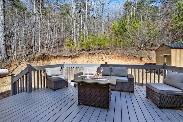 deck with an outdoor living space with a fire pit