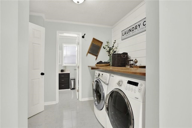 laundry area featuring ornamental molding and washer and clothes dryer