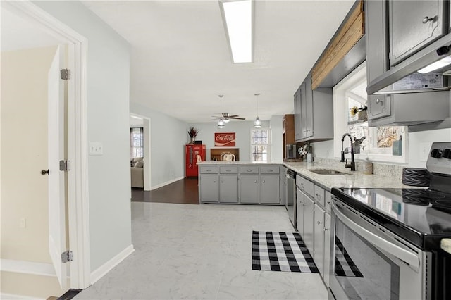 kitchen with gray cabinets, pendant lighting, sink, kitchen peninsula, and stainless steel appliances