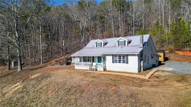 new england style home with a front yard and covered porch