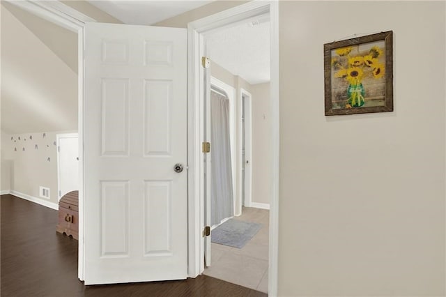 corridor featuring dark hardwood / wood-style flooring and lofted ceiling