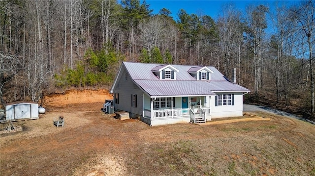 view of front of property with a front yard, central air condition unit, and covered porch