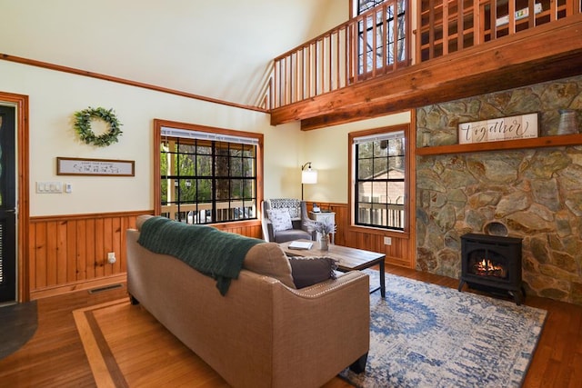 living room with high vaulted ceiling, a wood stove, a fireplace, and dark hardwood / wood-style floors