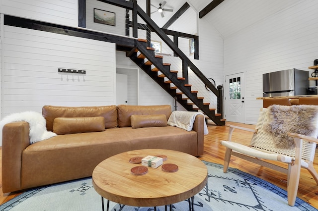 living room featuring beamed ceiling, ceiling fan, light hardwood / wood-style floors, and high vaulted ceiling