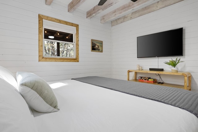 bedroom with beam ceiling and wooden walls