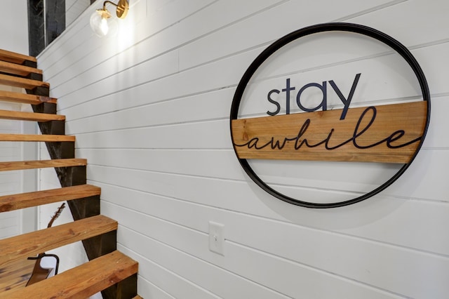 stairway featuring wood walls