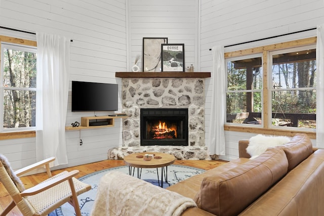 living room with wooden walls, a towering ceiling, and hardwood / wood-style flooring