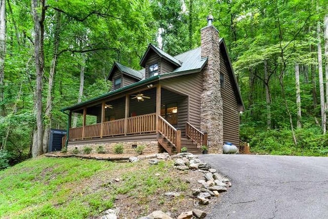 log cabin featuring ceiling fan and a porch