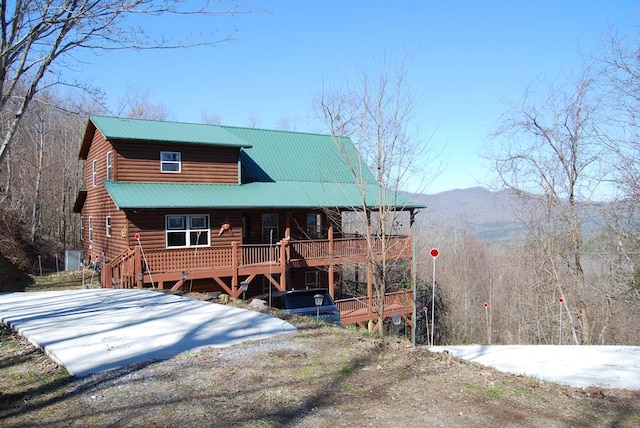 view of front of house with covered porch, a mountain view, and metal roof