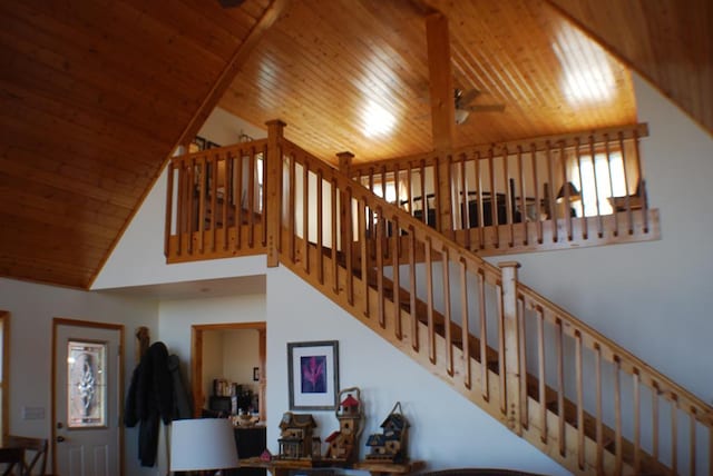 stairs with wood ceiling, a high ceiling, and ceiling fan