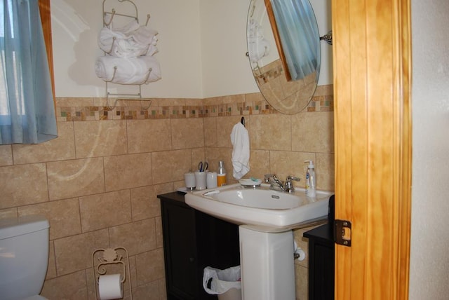 bathroom with toilet and tile walls