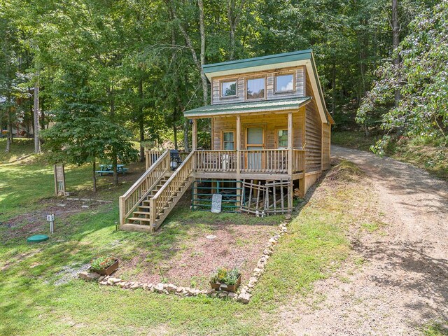 log cabin with a porch and a front lawn