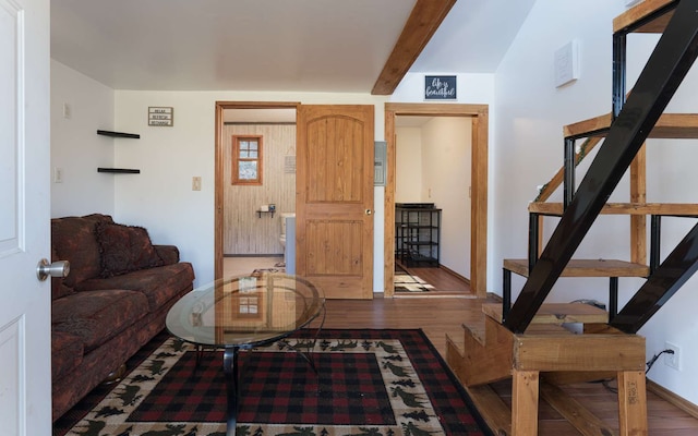 living room featuring vaulted ceiling with beams and wood-type flooring