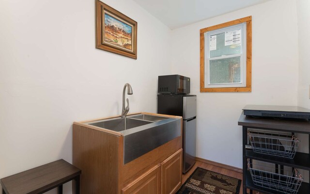 kitchen with stainless steel fridge and hardwood / wood-style floors