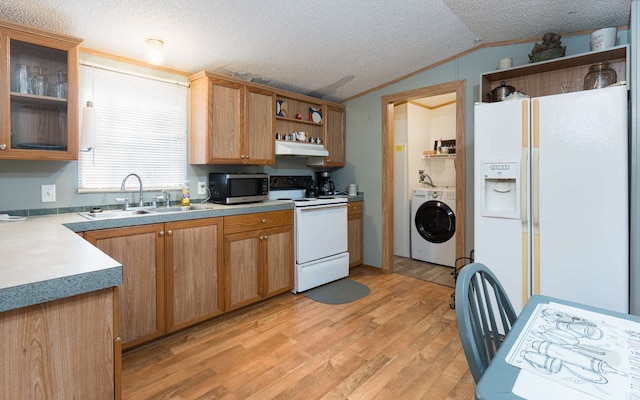 kitchen with white appliances, sink, light hardwood / wood-style floors, washer / dryer, and a textured ceiling