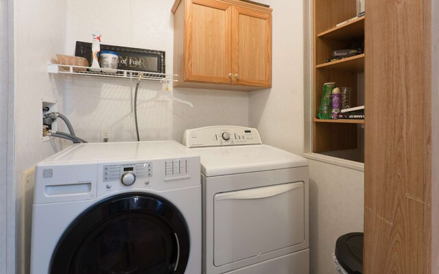 laundry area with washing machine and dryer and cabinets