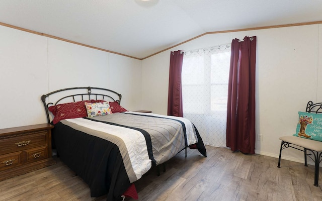 bedroom featuring lofted ceiling, wood-type flooring, and crown molding