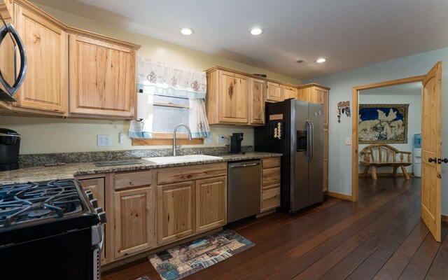 kitchen featuring light brown cabinets, sink, light stone countertops, dark hardwood / wood-style floors, and appliances with stainless steel finishes