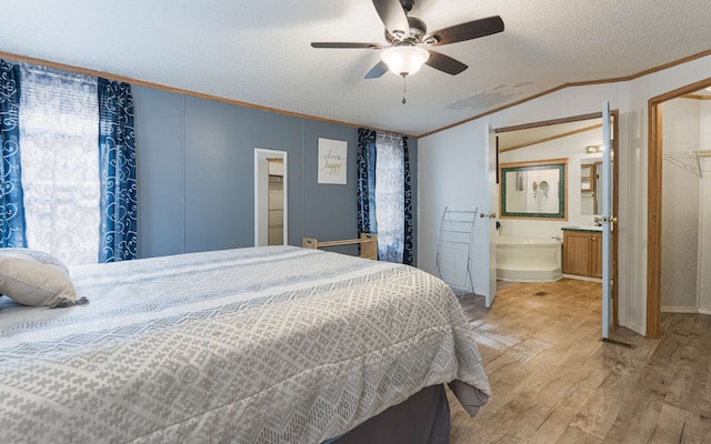 bedroom with a closet, a spacious closet, ceiling fan, light wood-type flooring, and a textured ceiling