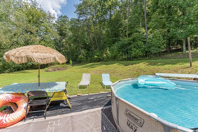 view of pool with a lawn