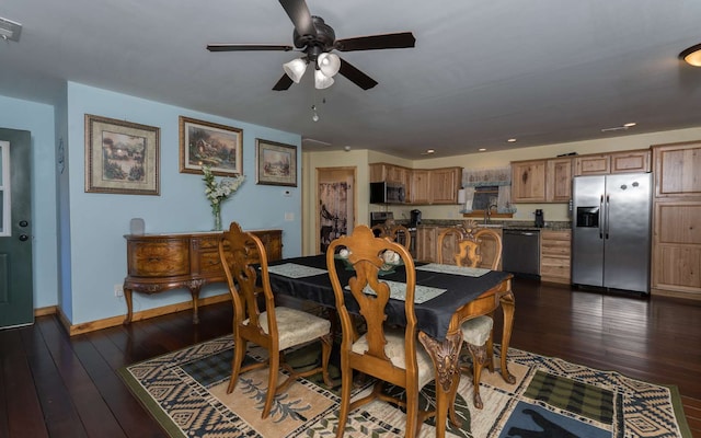 dining room with dark hardwood / wood-style floors, sink, and ceiling fan