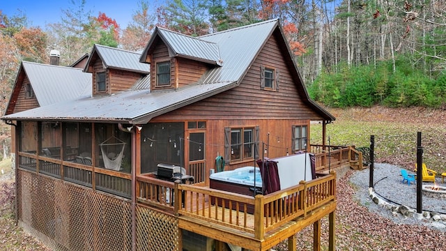 rear view of property featuring a hot tub