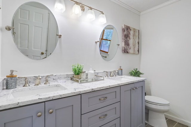 bathroom with toilet, vanity, and ornamental molding