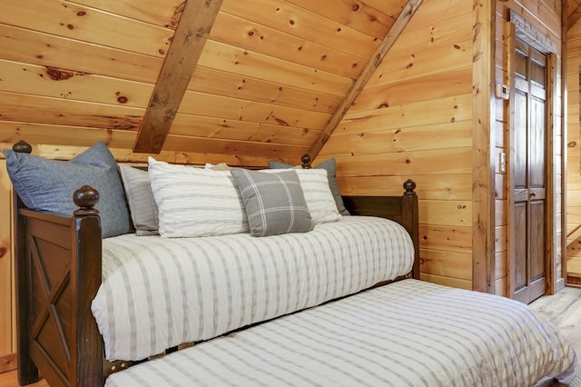 bedroom featuring light hardwood / wood-style floors, vaulted ceiling, wood ceiling, and wood walls