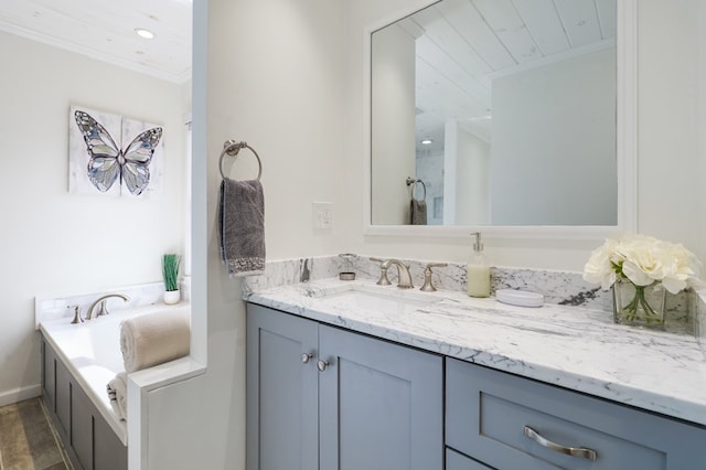 bathroom featuring a tub, vanity, ornamental molding, and hardwood / wood-style flooring