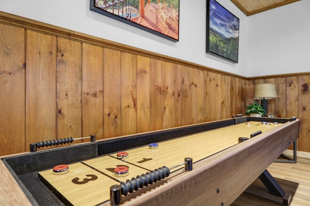 recreation room featuring hardwood / wood-style floors and wooden walls