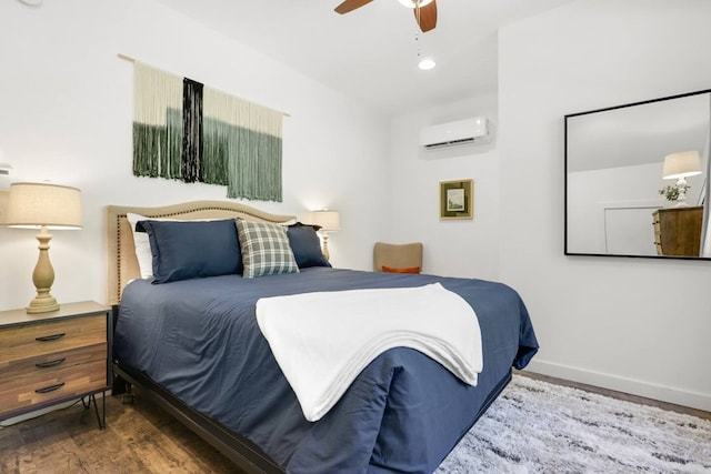 bedroom featuring a wall mounted air conditioner, hardwood / wood-style floors, and ceiling fan