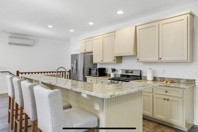 kitchen with stainless steel appliances, dark hardwood / wood-style flooring, a breakfast bar area, a kitchen island with sink, and custom exhaust hood