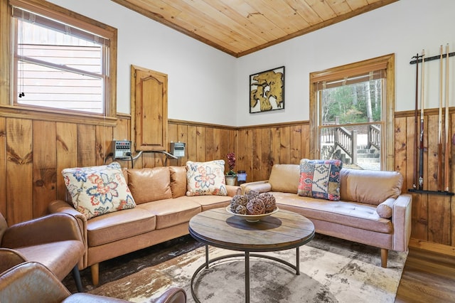 living room with crown molding, wooden walls, wood ceiling, and hardwood / wood-style flooring