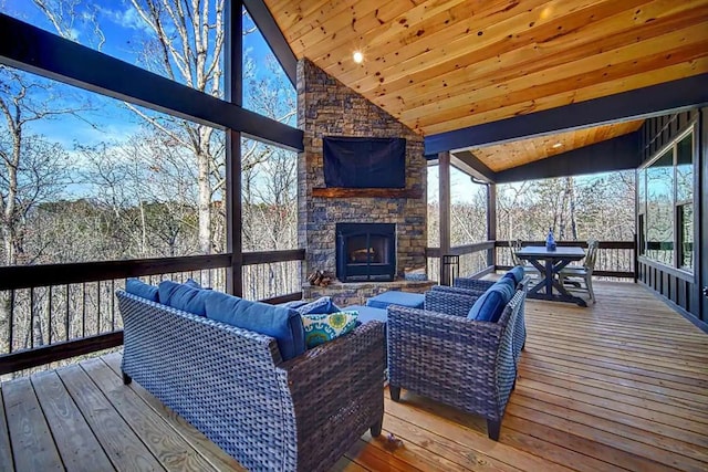 sunroom / solarium featuring wood ceiling, an outdoor stone fireplace, and vaulted ceiling