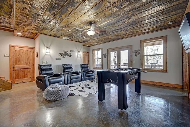 playroom with ceiling fan, wooden ceiling, concrete floors, baseboards, and french doors