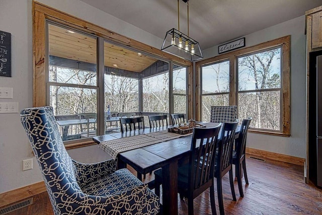 dining space with baseboards, visible vents, and wood finished floors